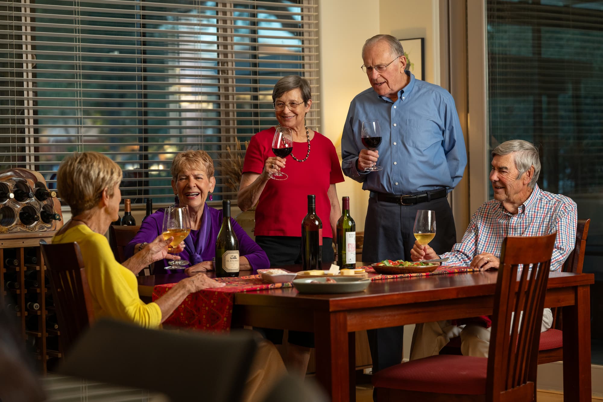 group of seniors enjoy a glass of wine together